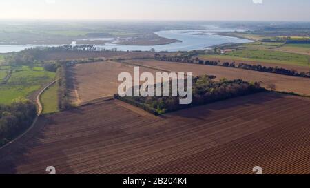 Ein Luftbild aus einer Drohne des Fluss-Deben-Estuary in Suffolk mit kürzlich gepflügten Ackerflächen im Vordergrund Stockfoto