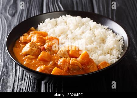 Erdnuß Domoda Eintopf mit Hühnerküken und einer Beilage Reis in einem Teller auf dem Tisch gekocht. Horizontal. Stockfoto