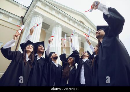Scrollt Diplome in den Händen von Absolventen. Stockfoto