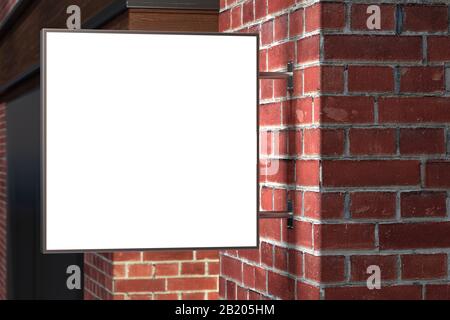 Quadratisches Einzel-Brett oder Schild an der roten Ziegelwand mit leerem weißem Schild. Nachtszene. Seitenansicht Stockfoto
