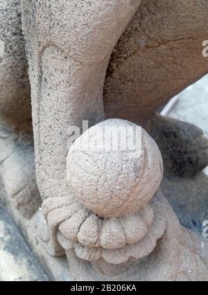 Alte chinesische Löwe Skulptur oder Erziehungsberechtigten Lion Holding eine Kugel im rechten Fuß am Eingang oder das innere Heiligtum, Symbol für Schutz und Leistung in Oder Stockfoto