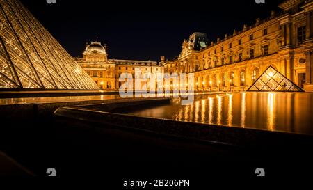 Louvre's Hof in der Nacht mit reflektierenden Pools. Paris, Frankreich. Stockfoto