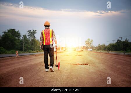 Ingenieur mit Distanzmessrad auf der Straße Stockfoto