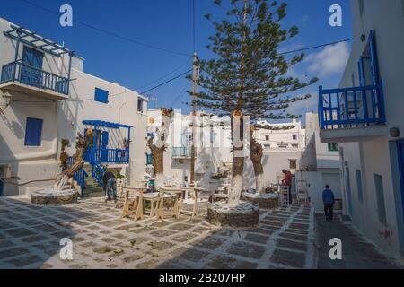 Enge Gepflasterte Straße auf der Insel Mykonos mit traditionellen Architekturgebäuden mit Häusern, Geschäften und Kirchen während einer nicht-touristischen Saison. Stockfoto