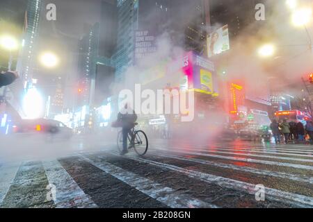 Der treibende Dampf umgibt die Gebäude People, Traffic und Times Square in der verschneiten Nacht in Midtown Manhattan New York City, New York, New York, New York, USA, am Jan. 2020. Stockfoto