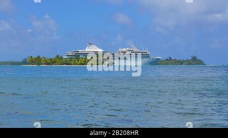 Kleine tropische Insel mit Kreuzfahrtschiff, südpazifischer Ozean, Französisch-Polynesien, Huahine Stockfoto