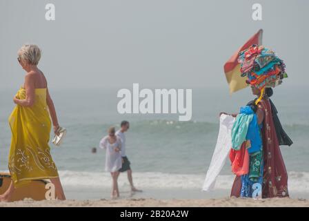 Indische Damen verkaufen Sarongs am South Goa Strand in Indien. Stockfoto
