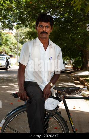 Bengaluru, INDIEN - 24. Oktober 2012. Der indische Mann sitzt auf seinem Fahrrad in einer Straße in Indiranagar, Bengaluru (Bangalore), Indien Stockfoto