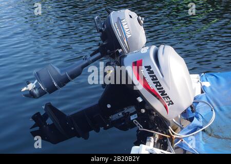 Nahaufnahme von zwei Außenbordmotoren auf der Rückseite eines Bootes aus dem Wasser. Ein Mariner Viertakt und ein Yamaha Viertakt Stockfoto