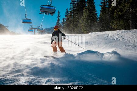 Der männliche Skifahrer genießt seine Fahrt auf dem Hang Stockfoto