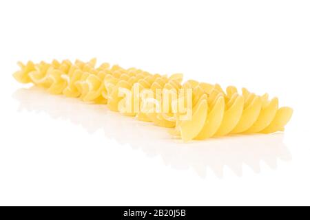 Viele ganze gelbe Nudelfusilli isoliert auf weißem Hintergrund Stockfoto