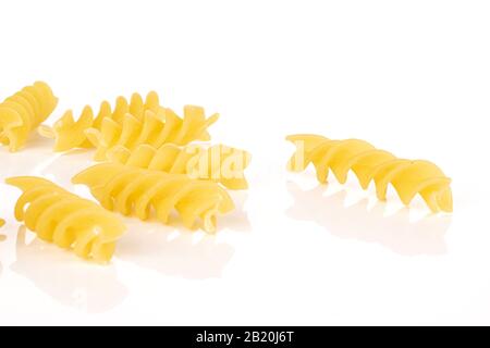 Gruppe von sieben ganzen hellgelben Nudelfusilli isoliert auf weißem Hintergrund Stockfoto