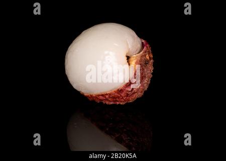 Eine ganze geschälte frische Lycee isoliert auf schwarzem Glas Stockfoto