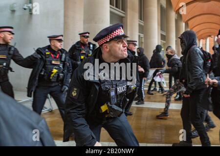 London, Großbritannien. Februar 2020. Angespannte Konfrontation zwischen Polizei und anarchistischen Gruppen während antikapitalistischer Proteste am Paternoster Square in London. Aktivisten heben ökologischen Zusammenbruch und systemische Ungleichheit hervor. Penelope Barritt/Alamy Live News Stockfoto