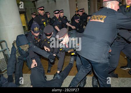London, Großbritannien. Februar 2020. Beamte der City of London Police verhaften einen Aktivisten während eines Protestes anarchistischer und antikapitalistischer Gruppen in der Nähe der Londoner Börse am Paternoster Square. Demonstranten heben die Auswirkungen des Kapitalismus auf die Ökosysteme der Erde hervor. Penelope Barritt/Alamy Live News Stockfoto