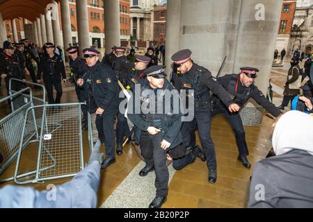 London, Großbritannien. Februar 2020. Die Polizei schimpft mit anarchistischen Demonstranten außerhalb der Londoner Börse. Verschiedene anarchistische und anti-kapitalistische Gruppen versammeln sich bei der Bank of England, bevor sie die Börse in Paternoster-Platz blockieren. Die Gruppen sind gegen das, was sie als willige Zerstörung der Ökosysteme der Erde und des kapitalistischen Systems ansehen, das diesen Prozess unterstützt. Penelope Barritt/Alamy Live News Stockfoto