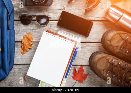 Set von Sachen und Touristenausstattung für Reisen und Abenteuer auf grauem Holzhintergrund. Draufsicht eingestellt. Sonnenlicht Stockfoto