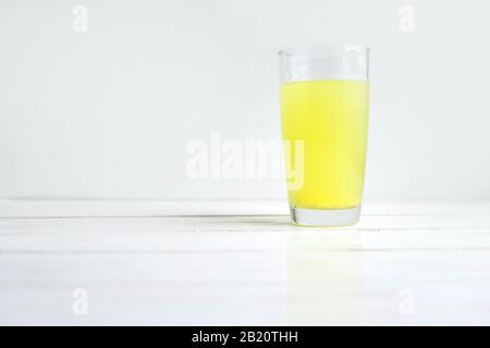 Glas Wasser mit gelöster gesunder Vitamintablette auf Weiß mit Copyspace Stockfoto