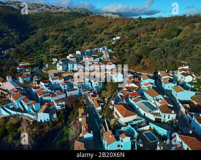 Luftdrone Blick auf Júzcar die Stadt bemerkenswerter Ort alle Wohnhäuser in blauer Farbe gemalt, Valle del Genal, Serrania de Ronda, Spanien Stockfoto