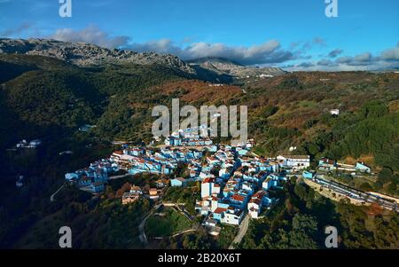 Luftdrone Blick auf Júzcar die Stadt bemerkenswerter Ort alle Wohnhäuser in blauer Farbe gemalt, Valle del Genal, Serrania de Ronda, Spanien Stockfoto