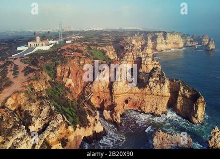 Panoramabildbild der Landzunge Ponta da Piedade mit einer Gruppe von Felsformationen gelb-goldene Klippen entlang der Küste von Kalksteinen, Lagos, Portugal Stockfoto