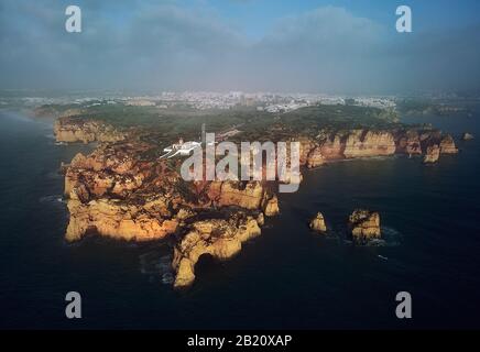 Luftferne Foto der Landzunge Ponta da Piedade mit Gruppe von Felsformationen gelb-goldene Klippen entlang der Kalkküste, Lagos Stadt Portugal Stockfoto