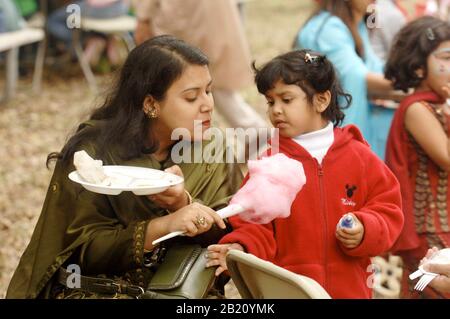 Austin, Texas 12. November 2005: Mutter und Tochter teilen sich am Ende des Ramadan (Eid) Festivals für die muslimische Gemeinschaft in Zentral-Texas Zuckerwatte. Die Veranstaltung zeigt Essen, Tanz und Feste der muslimischen Welt. ©Bob Daemmrich Stockfoto