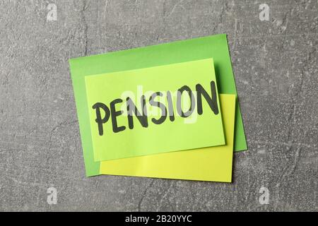 Aufkleber mit Aufschrift Pension auf grauem Hintergrund, Draufsicht Stockfoto