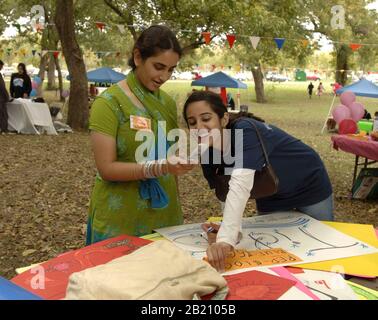 12. Nov. 2005, Austin TX USA: Muslimische College-Studenten, die am Ende des Ramadan (Eid) Festivals in Austin, Texas, eine SMS per Handy ansehen. ©Bob Daemmrich Stockfoto