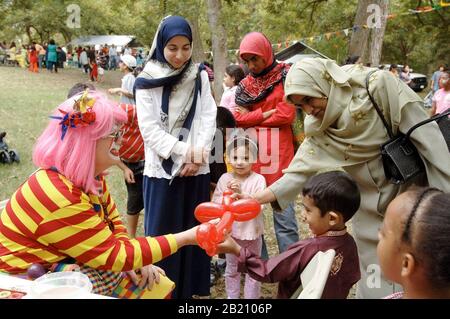 Austin, Texas 12. November 2005: Clown macht Ballonskulpturen für muslimische Kinder am Ende des Ramadan (Eid) Festivals für die muslimische Gemeinschaft in Zentral-Texas. Die Veranstaltung zeigt Essen, Tanz und Feste der muslimischen Welt. ©Bob Daemmrich Stockfoto