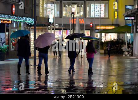 Menschen mit Regenschirmen in der nächtlichen Stadt Stuttgart, Baden-Württemberg, Deutschland Stockfoto