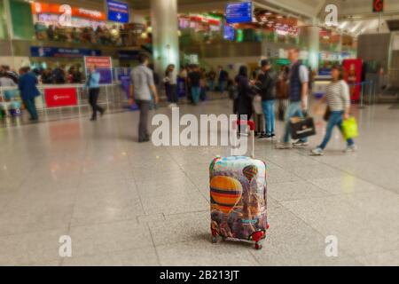 Türkei Alanya 18. April 2018: Ein Koffer mit einem hellen Bild inmitten des Flughafens auf dem Hintergrund einer Menschenmenge Stockfoto