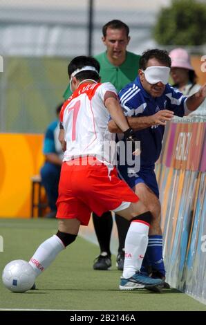 Korea (weiß und rot) gegen Griechenland beim 5-a-Side-Fußballwettbewerb bei den Paralympics in Athen. Von links nach rechts, #7 ist Jong Suk Yoon aus Korea und nicht identifizierter Spieler aus Griechenland. ©Bob Daemmrich Stockfoto