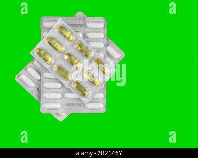 Kapseln und Pillen in Blisterpackungen auf grünem Hintergrund. Tablets. Medizinstymbol. Medikamente Medikamente Medikamente. Kopierbereich Stockfoto