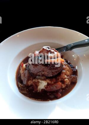 Geschmortes Lamb Osso Bucco auf einem Bett aus cremigem Knoblauchpüree, Kartoffelpüree und in einem Gemüse-Ratatouille erstickt. Stockfoto