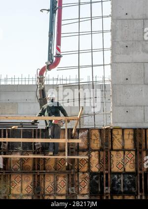 Grand Rapids Michigan USA 8. März 2019; ein Arbeiter steht auf Gerüsten, während er an der Errichtung einer Zementkonstruktion auf einer Baustelle arbeitet Stockfoto