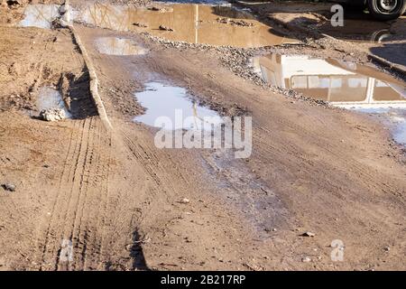 Pfütze und Schlamm auf einer sandigen Straße Stockfoto