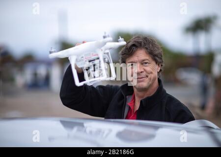 Gutaussehender Mann, der eine Drohne hält. Stockfoto