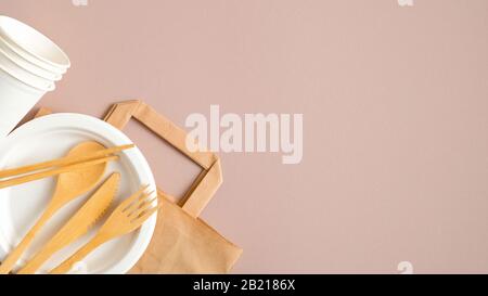Eco Store Banner Designvorlage. Leere Papiertasche aus Kraftpapier und umweltfreundliches Besteck auf braunem Hintergrund. Flache Lage, Draufsicht. Nachhaltiger Lebensstil. Z Stockfoto