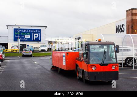 Februar 2020 EIN batteriebetriebenes Wanzi-Einkaufswagen-Rückgewinnungsfahrzeug bei der Arbeit vor Marks und Spencer im Parkplatz des Bloomfield Shopping Centers Stockfoto