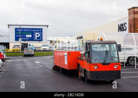 Februar 2020 EIN batteriebetriebenes Wanzi-Einkaufswagen-Rückgewinnungsfahrzeug bei der Arbeit vor Marks und Spencer im Parkplatz des Bloomfield Shopping Centers Stockfoto