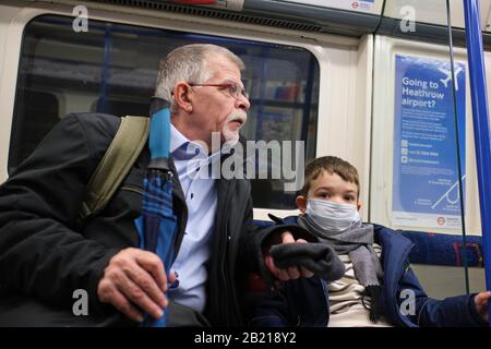 Kind trägt Gesichtsmaske als Schutz gegen Coronavirus, im Londoner Untergrund Stockfoto