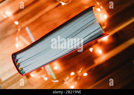 Draufsicht über ein rotes Buch mit bunten Lesezeichen. Stockfoto