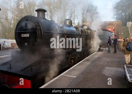 Eine funktionierende Dampfeisenbahn am Bahnsteig am Bahnhof Bishops Lydeard der West Somerset Railway Line mit Eisenbahnfreunden, die mit dem Fahrer plaudern Stockfoto