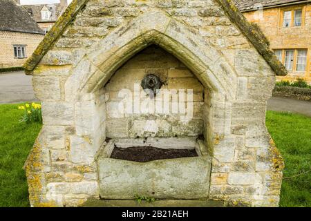 Wasserbrunnen in Lower Slaughter in Gloucestershire. Das Dorf liegt in der Nähe von Bourton am Wasser in den Cotswolds und ist ein beliebter Besucherzuspruch. Stockfoto