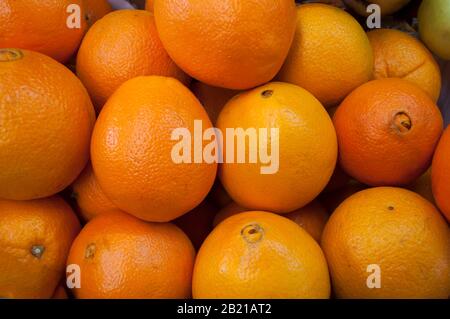 Orangen auf dem Markt. Reife, frische, gelbe Orangen werden im Lebensmittelgeschäft, Obst und Gemüse, in der Nähe verkauft. Viele Orangen. Template.Foo Stockfoto