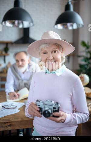 Lächelnde Seniorin mit Filmkamera Stockfoto