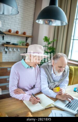 Älteres Paar, das Online-Zahlungen mit der Kreditkarte abwickeln kann Stockfoto