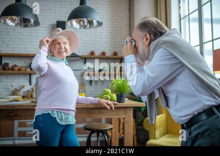 Ältere Frau posiert, während ihr Mann fotografiert Stockfoto
