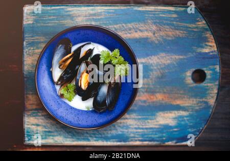 Draufsicht auf eine Schüssel köstlicher Suppe mit Garnelen und Muscheln, die im Restaurant auf den Tisch gelegt werden Stockfoto